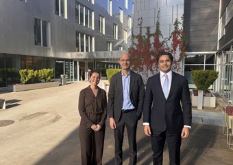 To men and one woman smiling to the camera